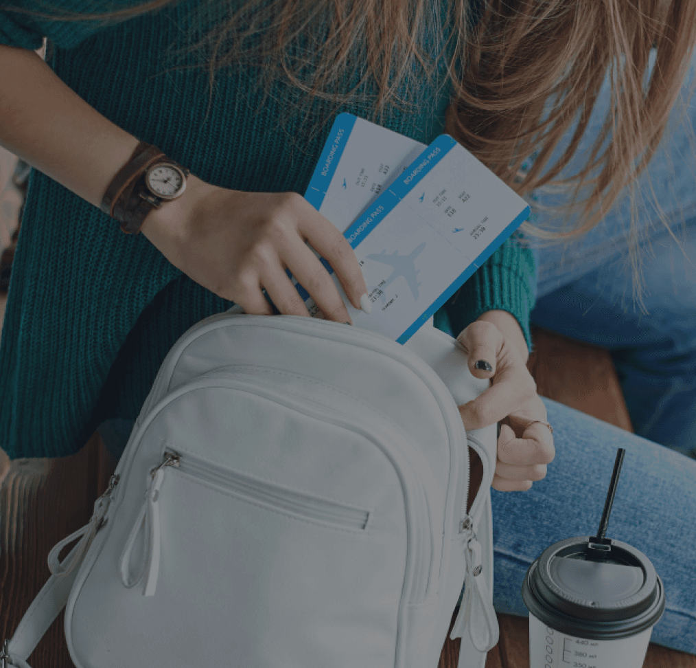 Woman puts two airline tickets in a rucksack