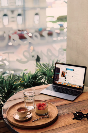 a laptop on the table and the cup of coffee